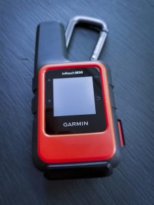 Garmin inReach mini in orange with carabiner hooked at top