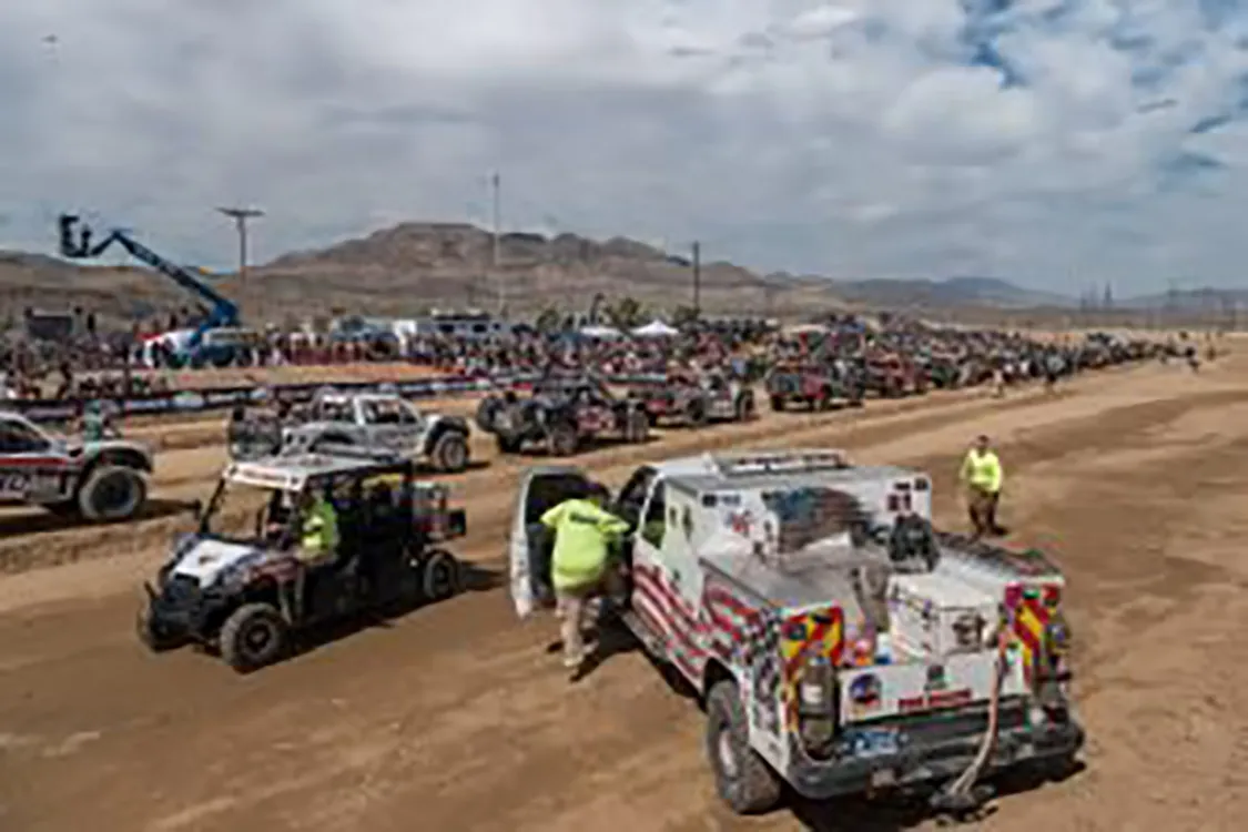 The trucks are lined up at the start and safety gets set at 2020 Mint 400.