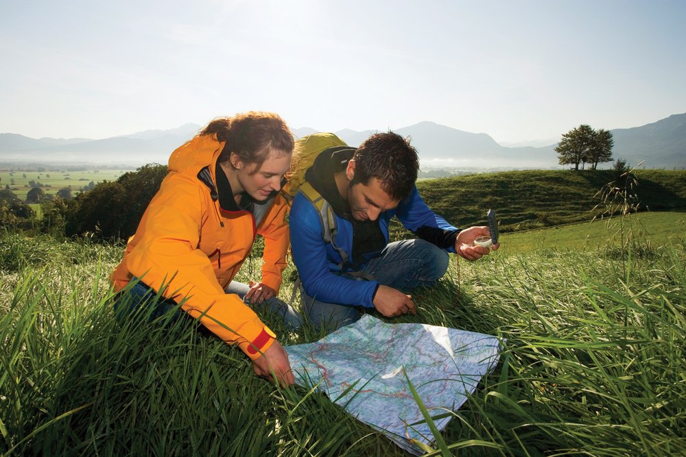 Couple using a compass and map for backcountry navigation