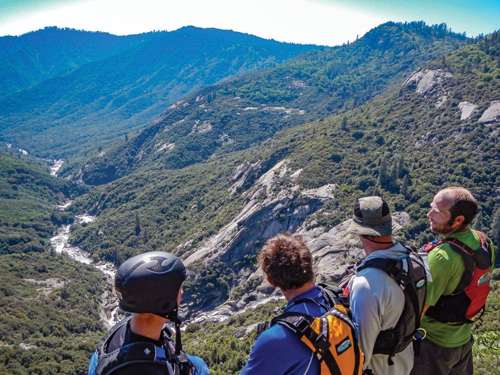 Kayaking team looking down at a remote river