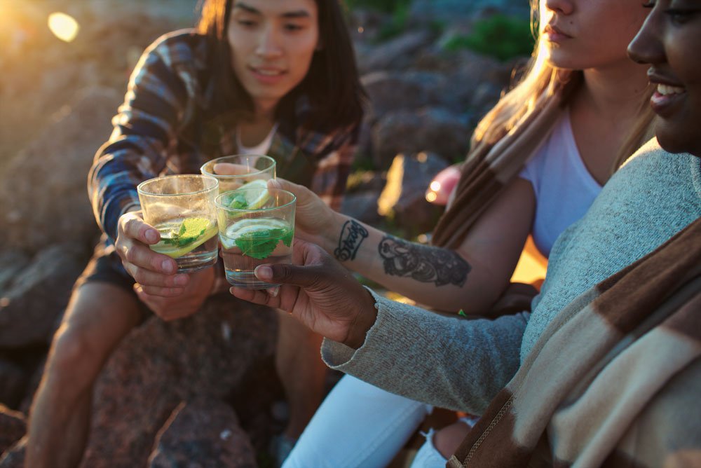 Three people cheers their camping cocktails