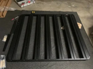 Assembling Front Runner Roof Rack on drop cloth on floor of garage