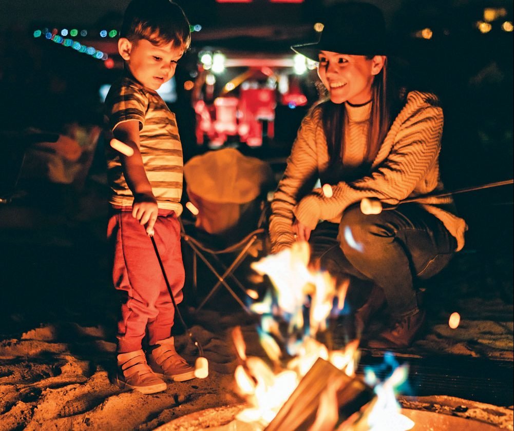 Mother and son roasting marshmallows at the campfire