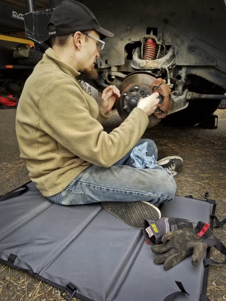 Man uses Creeper While Working on his Car