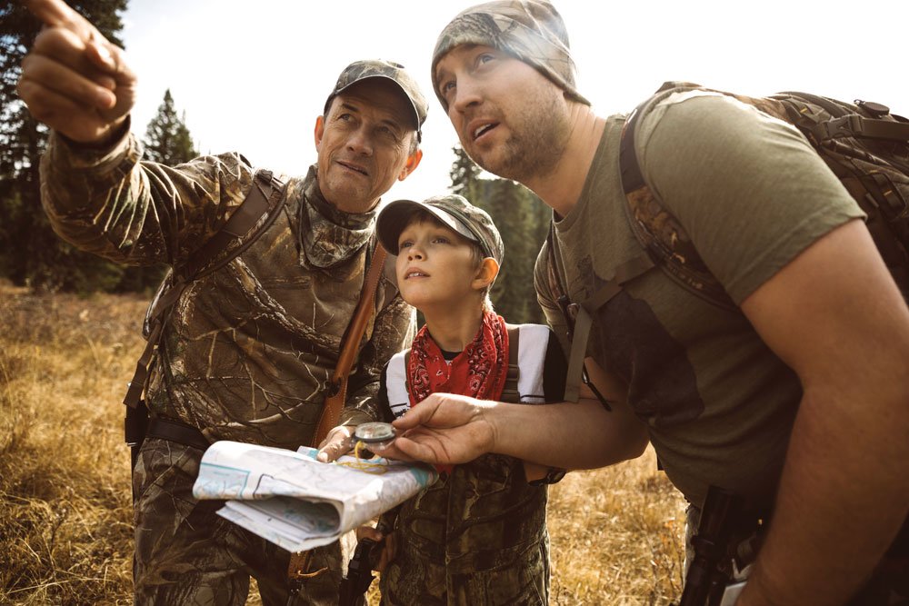 Three travelers using a map and compass