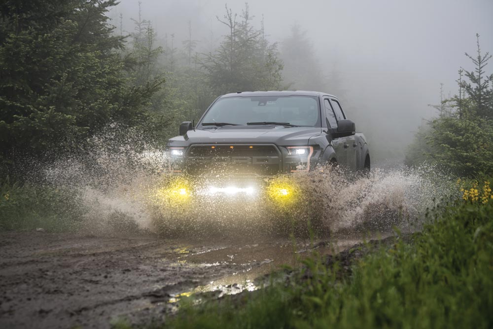 2018 Ford Raptor Supercrew driving through muddy water