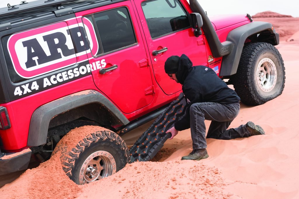 Man using recovery board to get stuck vehicle