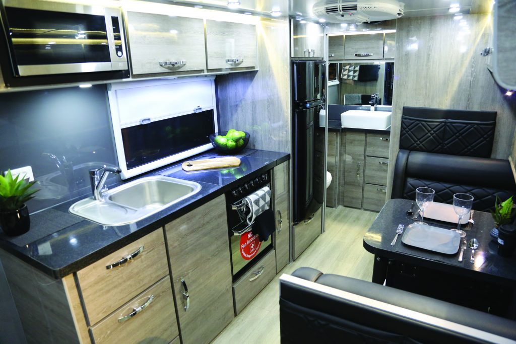 The camper is equipped with a kitchen that has a fullsize refrigerator