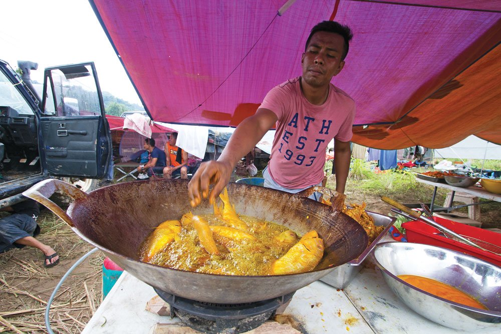 tThe RFC cook crew prepares rice, noodles, and some type of meat