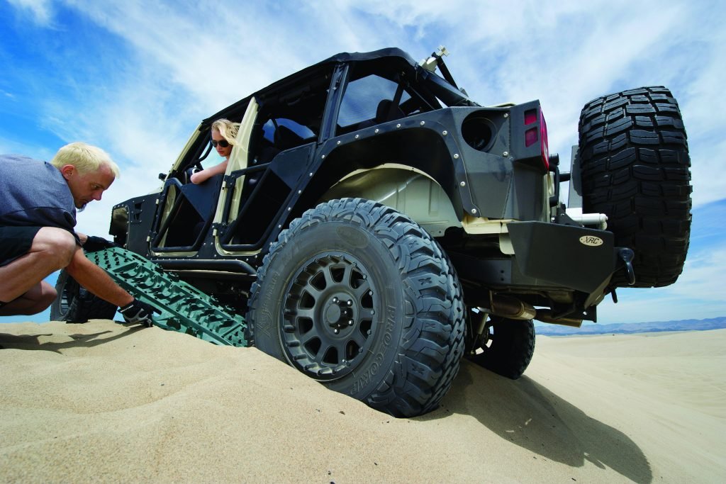 Man using a recovery board to get vehicle unstuck