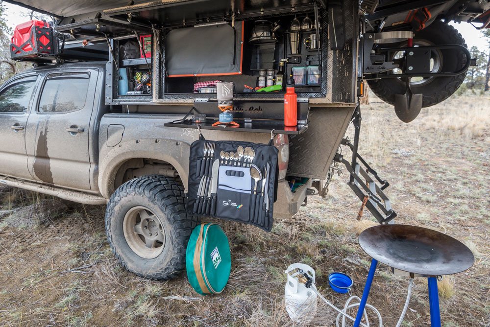 Alu-Cab camper door is open to show all the camp kitchen accessories.