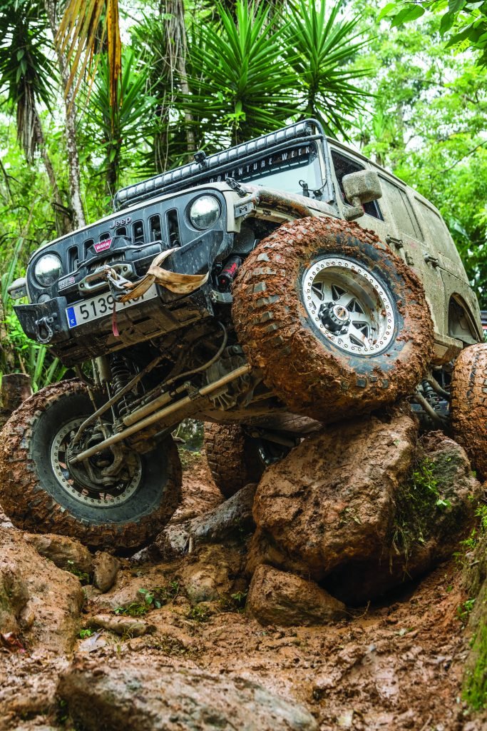 Jeep climbing giant, muddy rocks