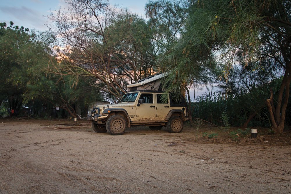 The Jeep is tucked into the trees in a camp spot found in Ethiopia