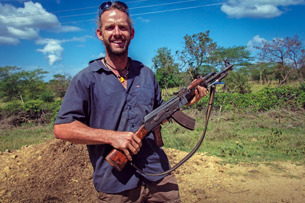 World traveler Dan Grec poses with AK-47 in Ethiopia.