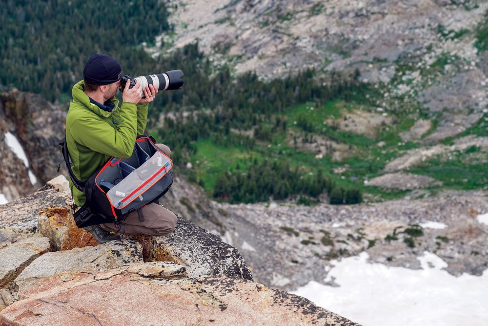 Man taking photos, easily able to access his camera with a proper storage bag