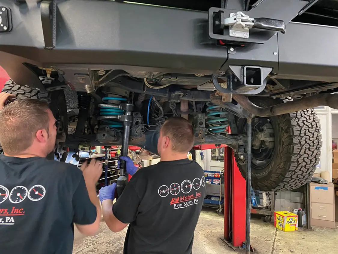 Two guys from J&J Motors installing the Load-Leveling System