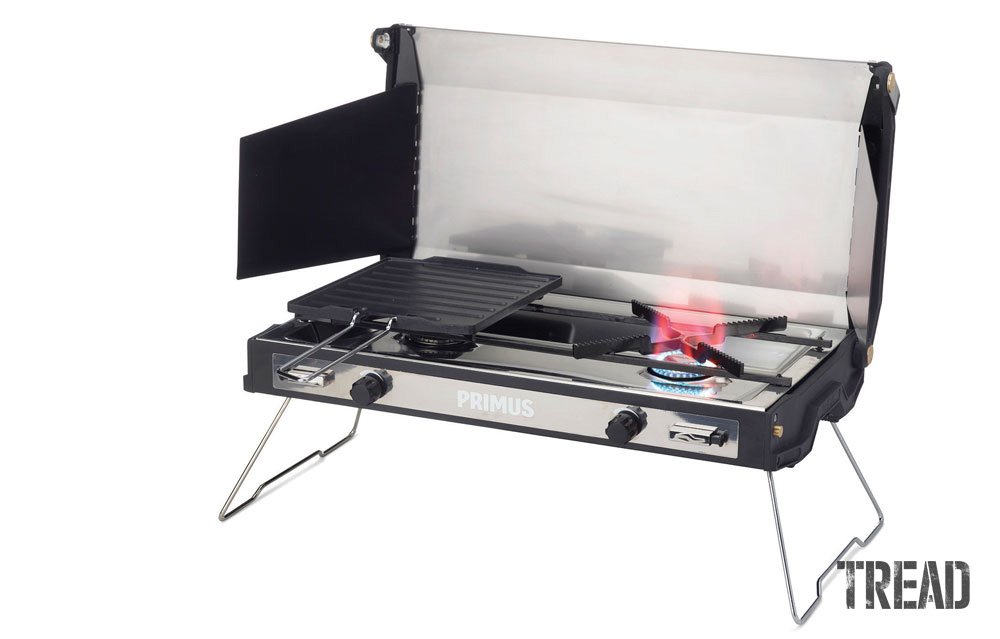 Primus Tupike portable stove with lid open to show two burners and included grill pan.