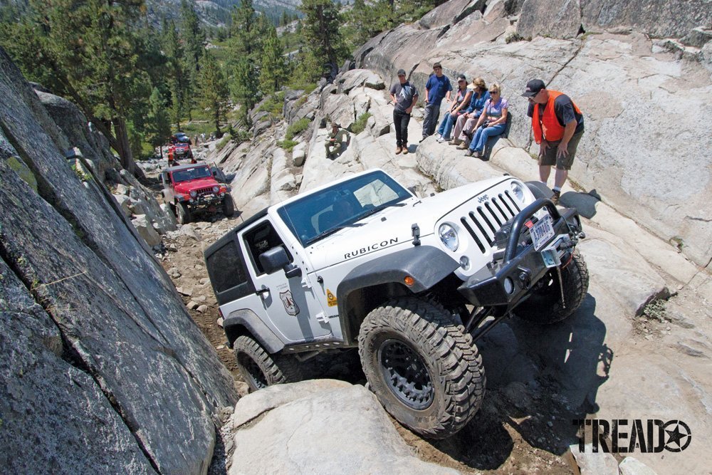 White Jeep climbs rocky terrain for the Sierra Trek with Cal4Wheel group.