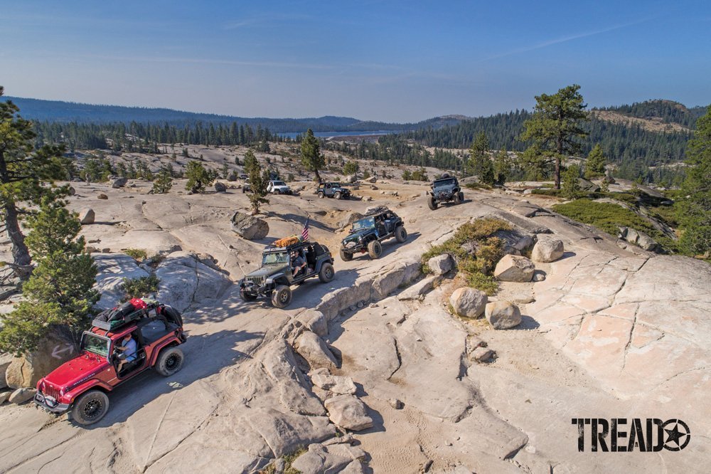 Different customized 4x4 vehicles driving on rocky off-road trail