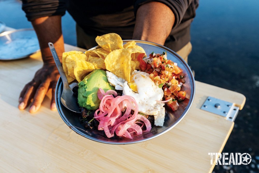 Camp Yoshi's professionally cooked meals offered all food groups, making a colorful plate held in the hand, with a bamboo table underneath it.