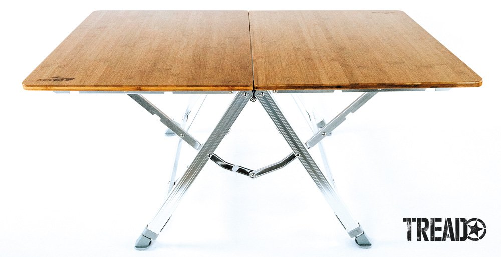 The Kovea Bamboo One Action Table folds in half with its chrome legs nesting inside of the tabletop.