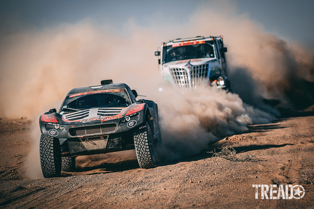 2021 Dakar Team #348 (Alexandre Leroy) drove in dusty dirt roads ahead of massive truck. 