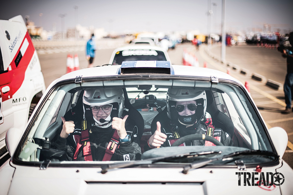 Amy Lerner (driver) and Sara Bossaert (co-driver) of Team #202 AL Rally give thumbs up while parked in Lerner's Porsche rally car.