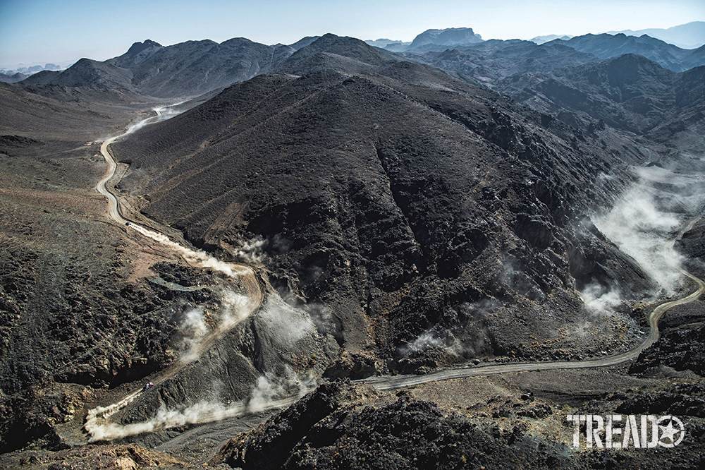 During the ninth stage of the Dakar 2021 between Neom and Neom, Saudi Arabia, teams raise dust as they curve around huge mountainsides. 