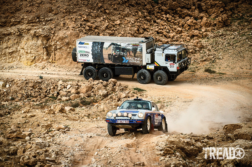 Team Lerner’s blue and white #202 Porsche rallies ahead of a MAN truck competing as a Classic entry in the truck category. 