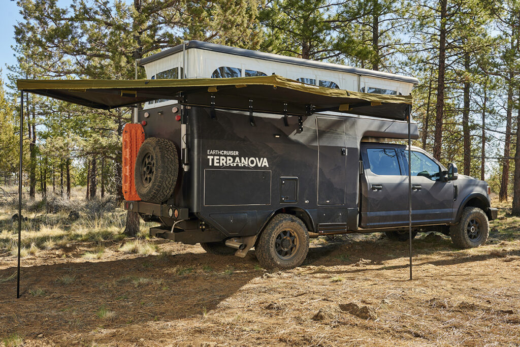 side view of black camper with pop top open and awning open