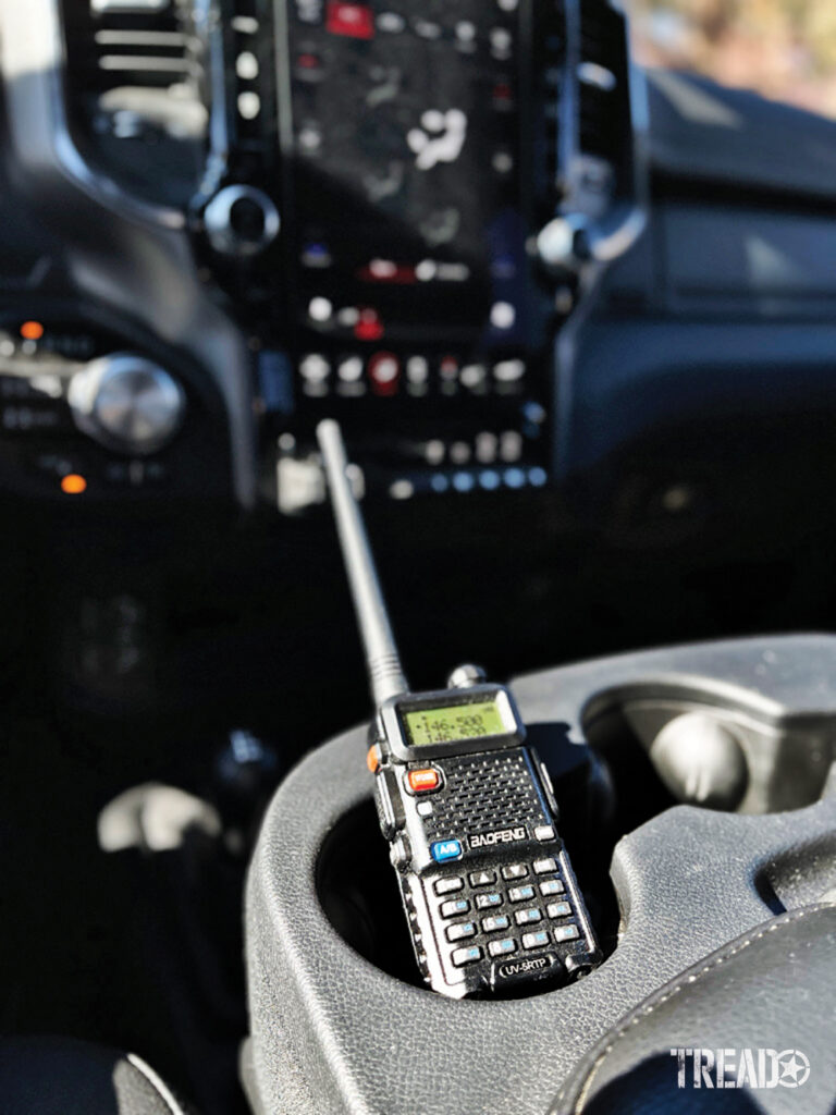 This black handheld radio sits in a centrally located gray cup holder.