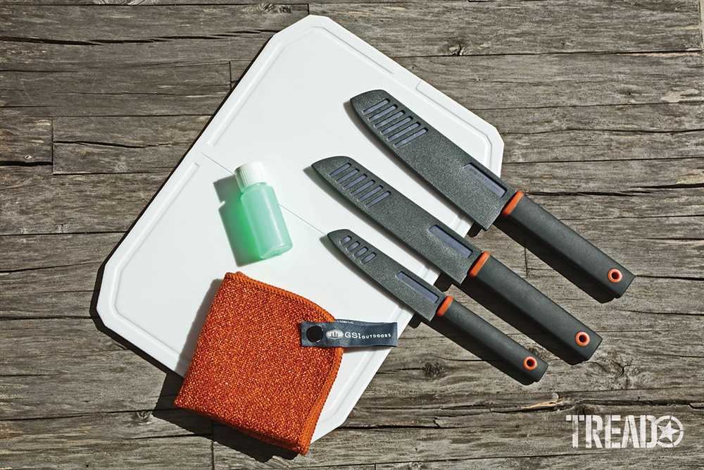 This knife set comes with a white cutting board, three knives as well as orange square dishcloth and bottle for soap.