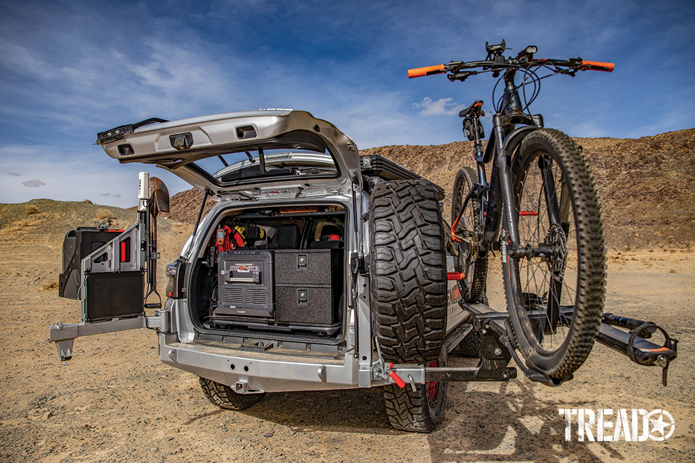 Family camping gear and off-road essentials are neatly stored in back, along with the Dometic fridge/freezer as the dual swing-away tire and jerry car carrier.