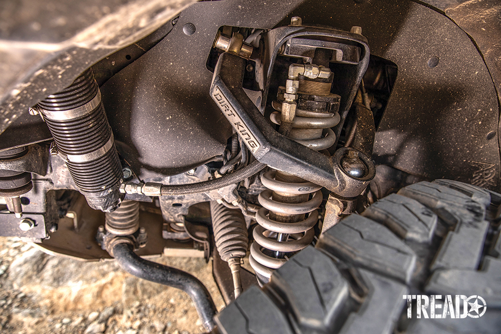 Dirt King Fabrications upper control arms and Radflo shocks hide behind a knobby off-road tire.