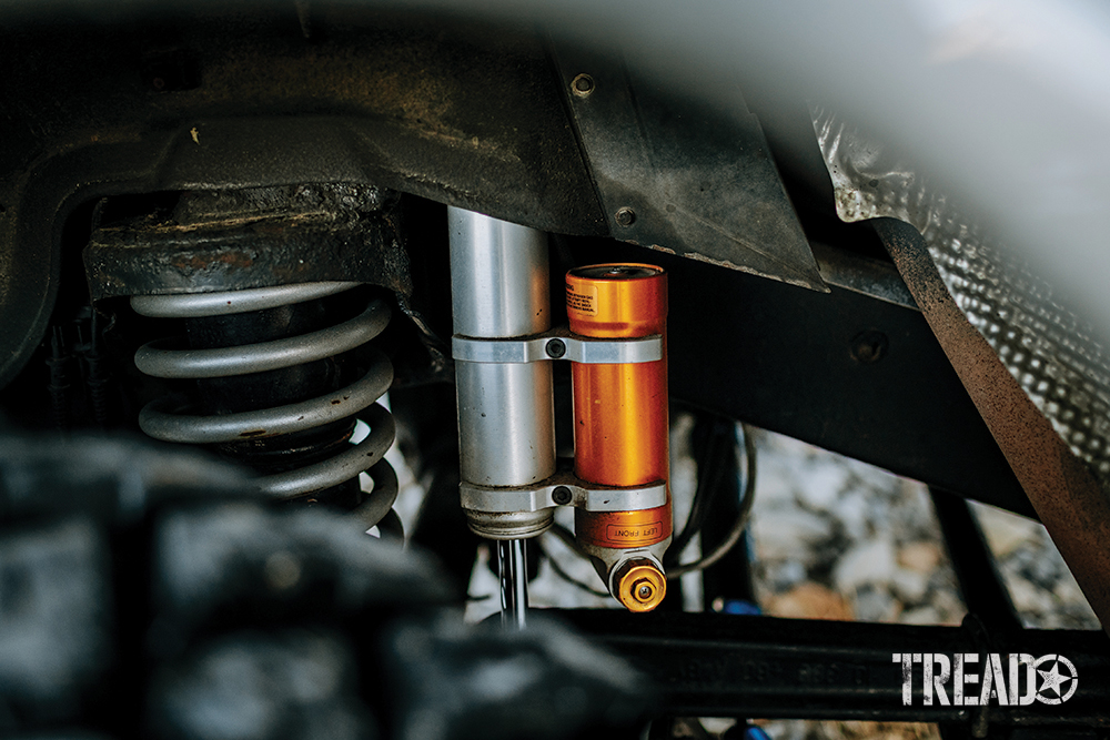 Silver and orange MEV Reservoir shocks sit behind beefy off-road tires. 