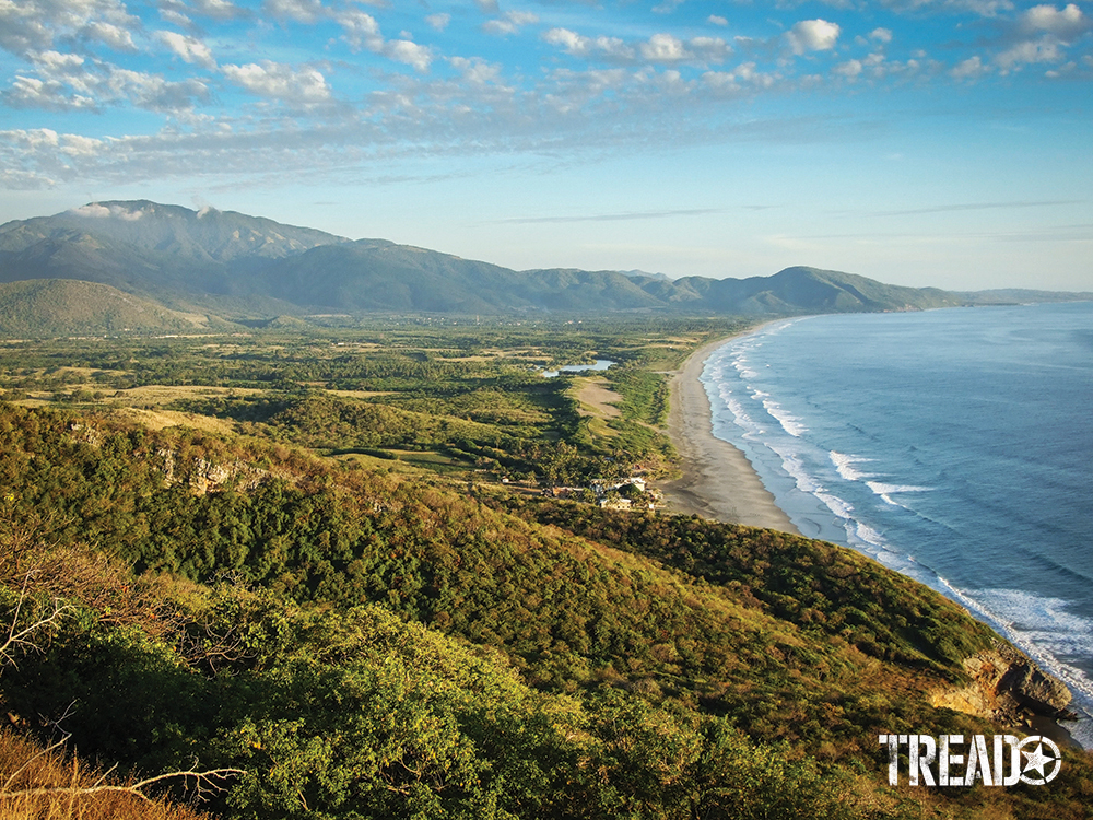 Undulating hills and green shrubs clear their way to Mexico's beaches, with waves wafting into shore.