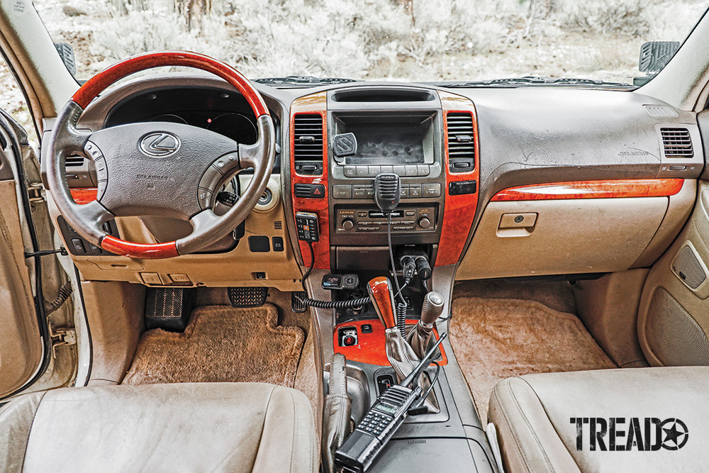 The tan, gray, and wood-accented cockpit of the of-road GX 470 is functional and simple.