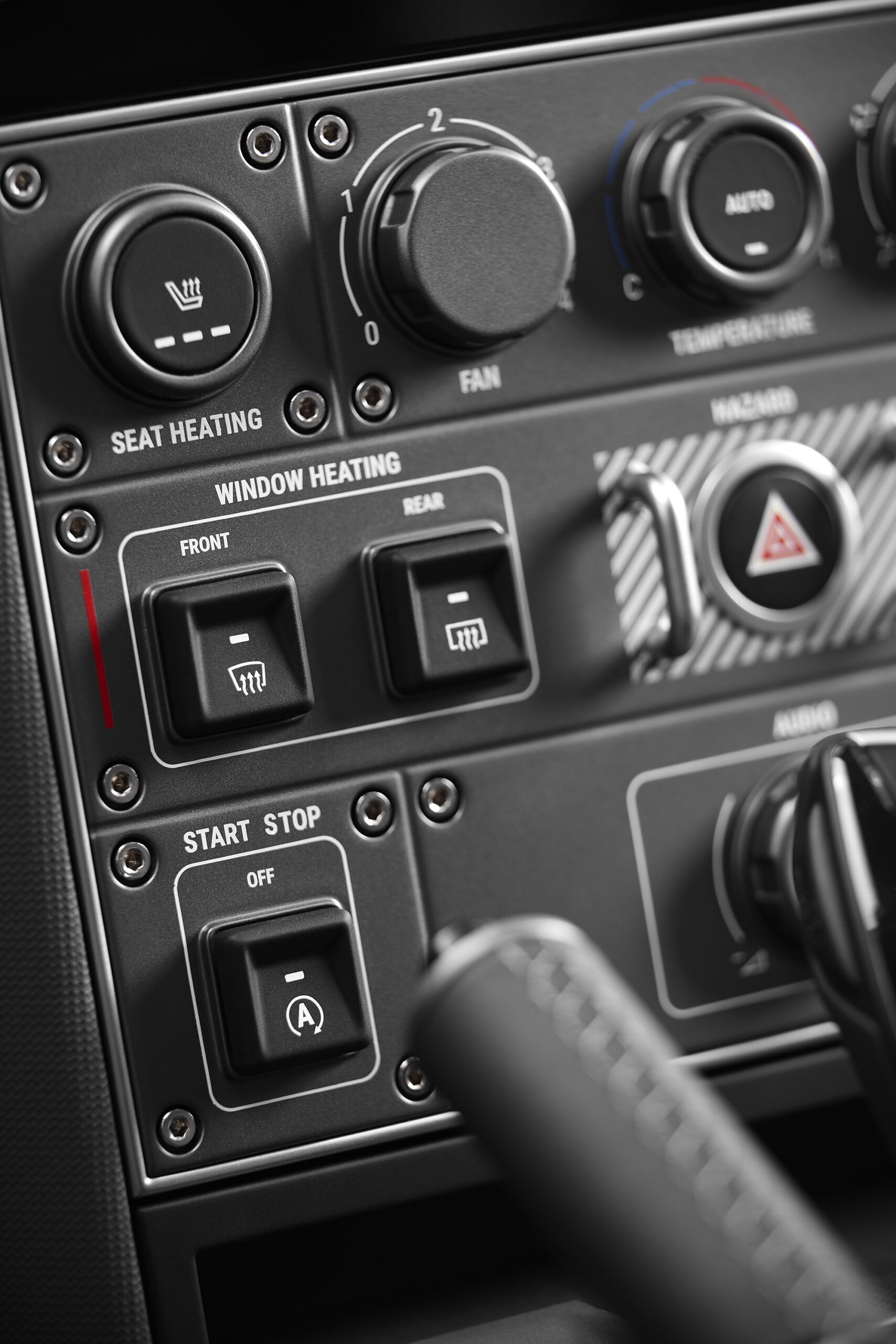 The INEOS interior includes oversized black toggle switches, rotary dials, and evenly spaced controls. 