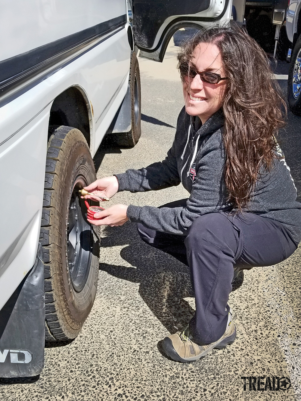 Woman deflates the Delica Star Wagon’s tires with an ARB E-Z deflator.