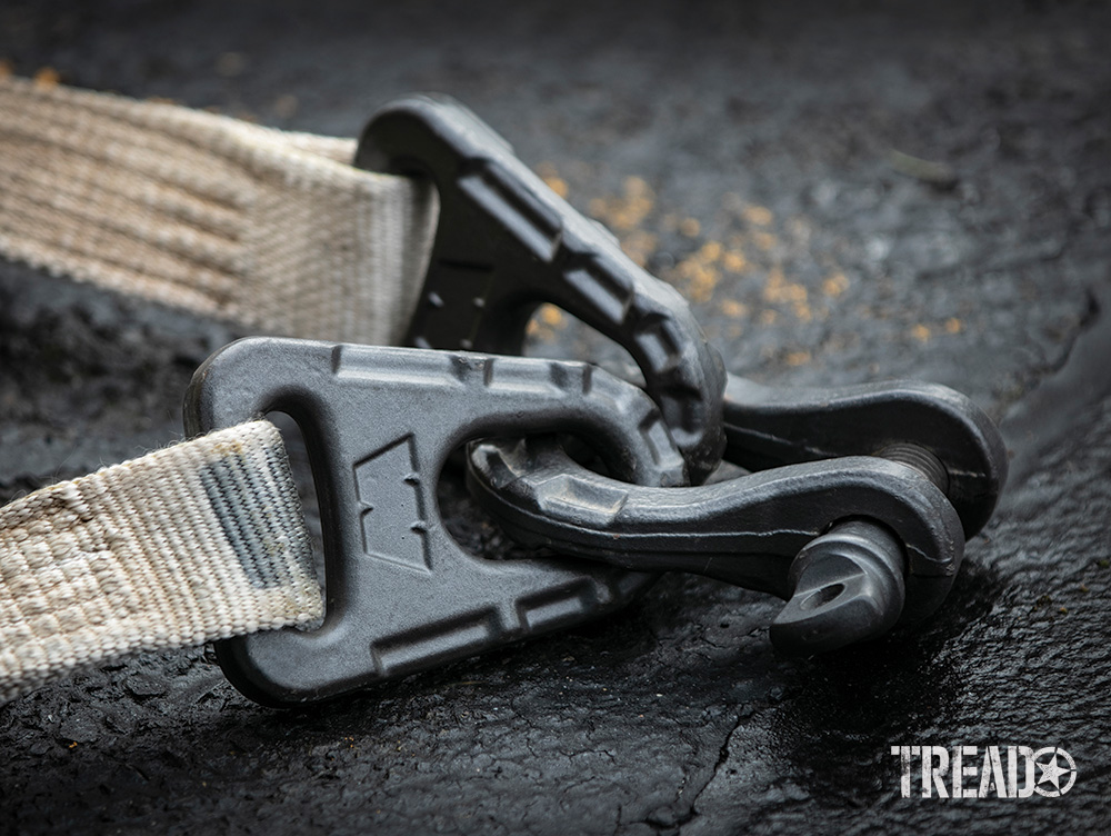 A WARN Epic tree trunk protector and Epic shackle lay on the pavement during a demonstration.