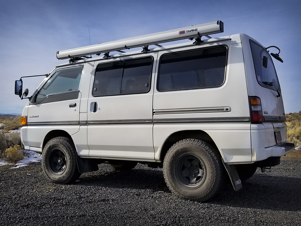 Side view of white Delica Star Wagon parked on road.