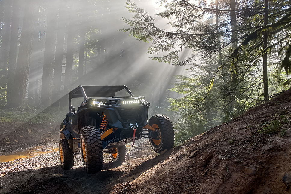 Can-Am Commander XTP Adventure parked on dirt with sun beaming down on it.