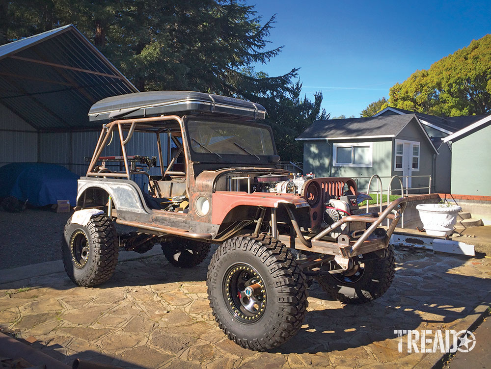 A shell of a Willys M38A1 with a rooftop tent mounted during the initial build.