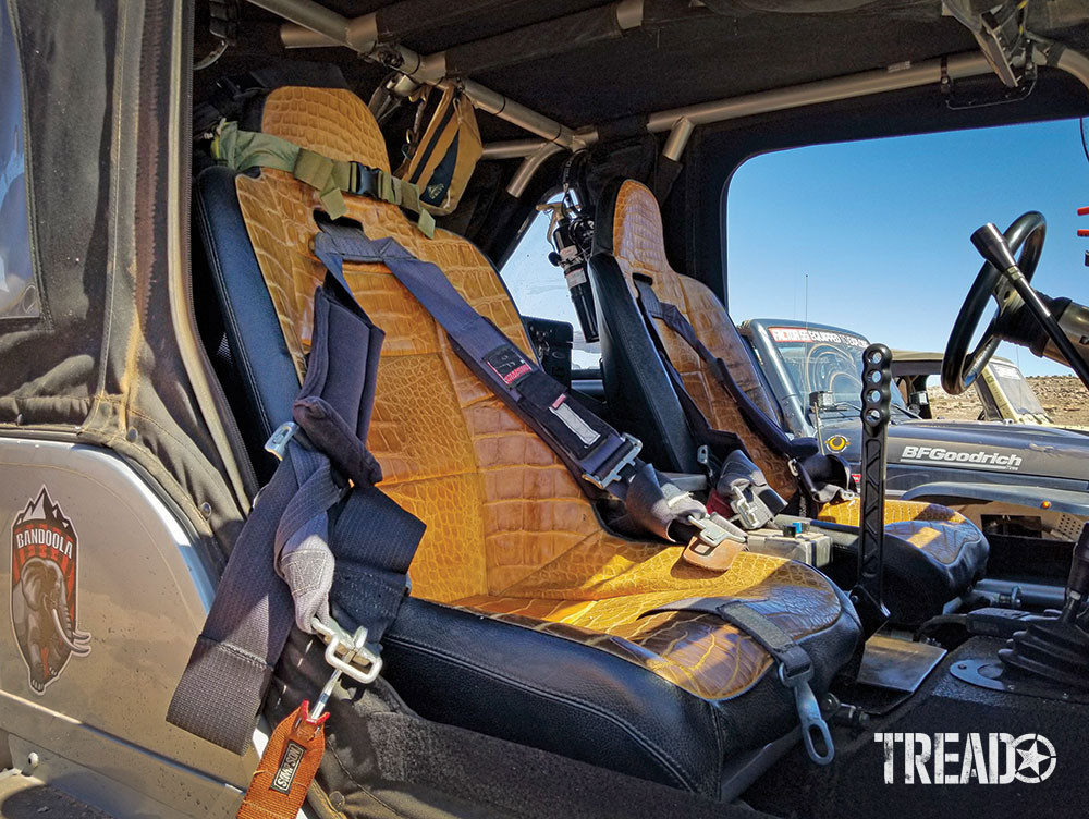 Interior of Jeep showing yellow alligator seats and harnesses.