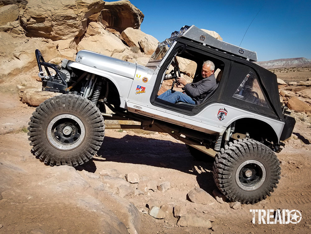 Jeep drives over rocky terrain.