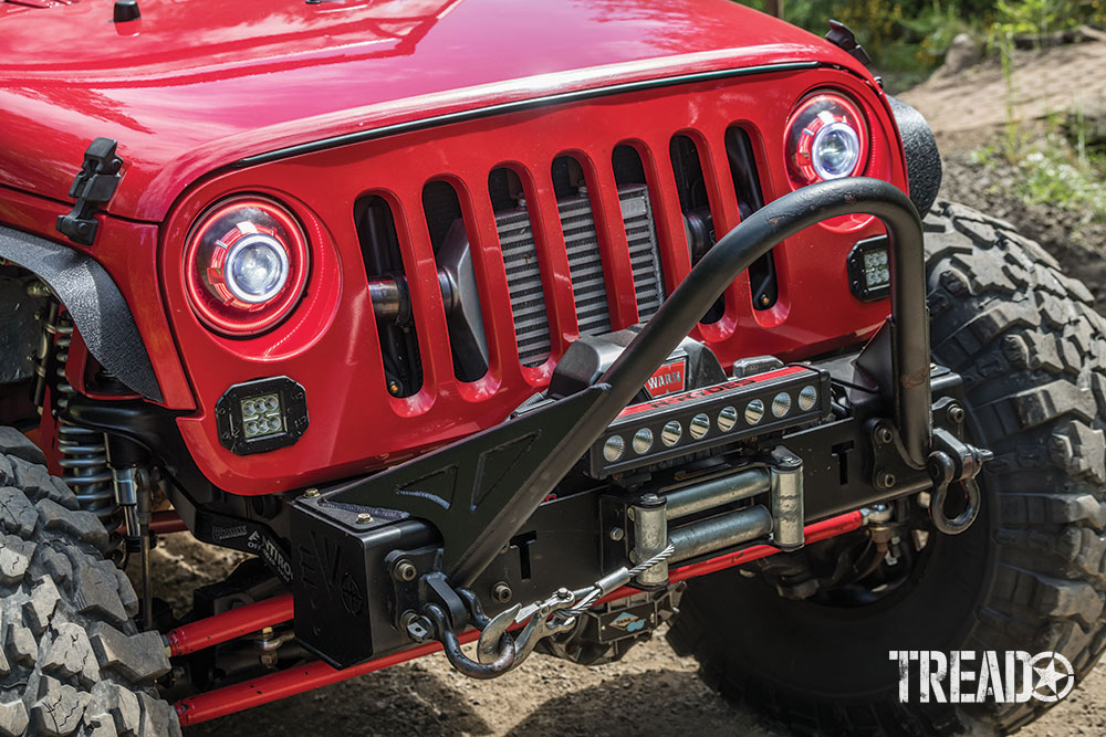 A black stinger bumper and Warn winch are attached to a red Jeep JKU.