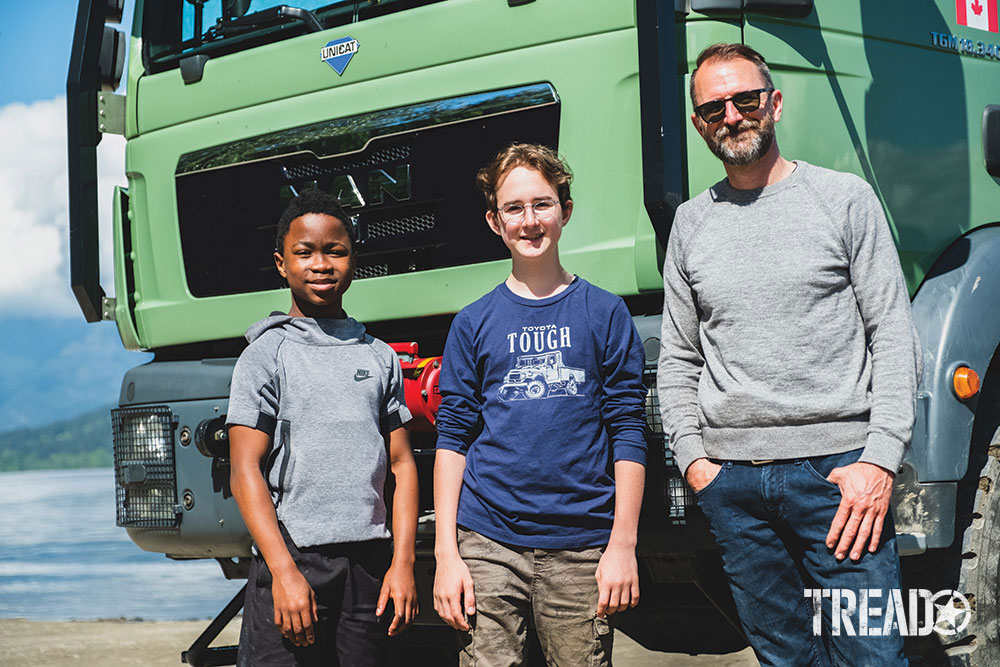 Aaron Leveille and his sons pose in front of their mint green MAN expedition truck.