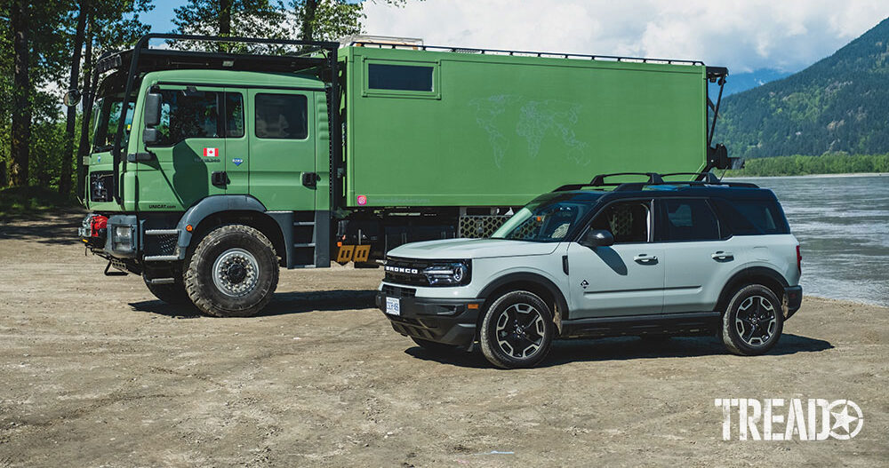 Mint Green MAN Expedition Truck parked next to Bronco Sport