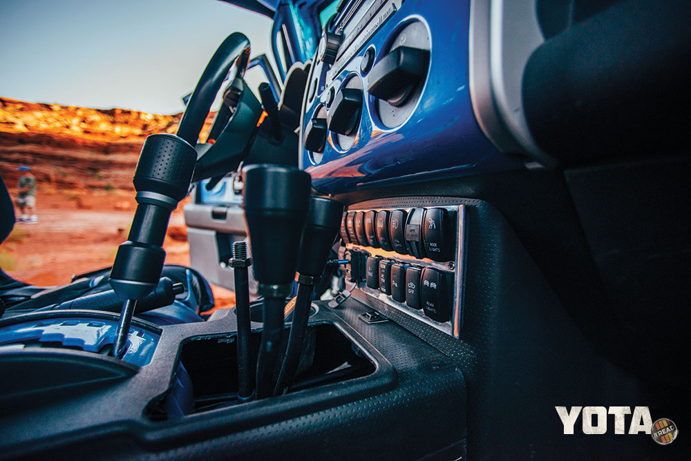 Three gear shift knobs are seen inside a blue FJ Cruiser.