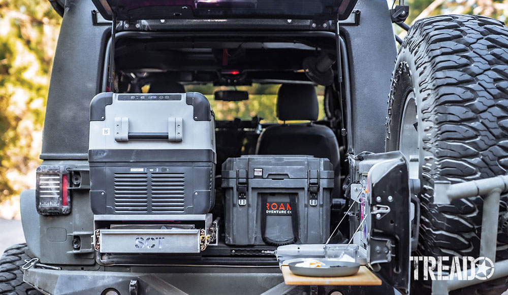 A ROAM Adventure Co. case, holding gear and camp kitchen supplies, sits perfectly next to the Dometic fridge and oven slideout in rear of Jeep..